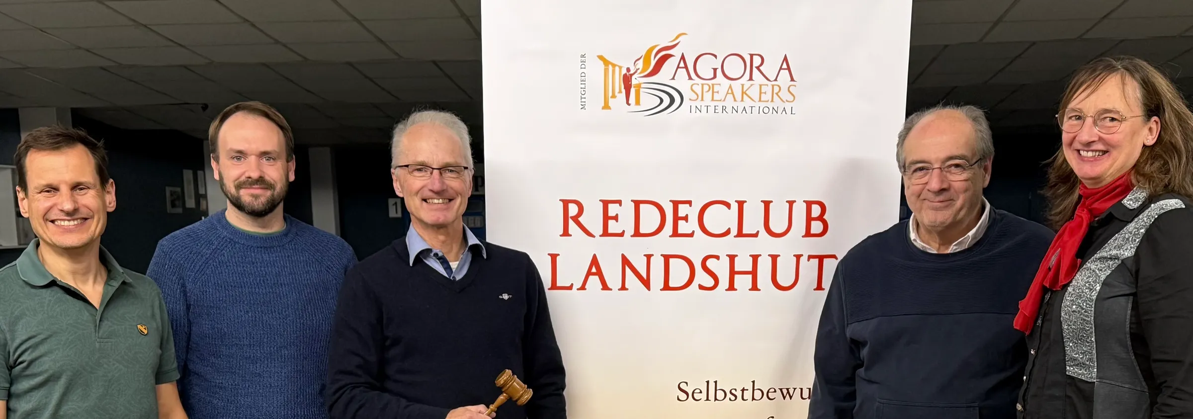 Mitglieder des Redeclub Landshut vor dem Roll-up-Banner des Clubs